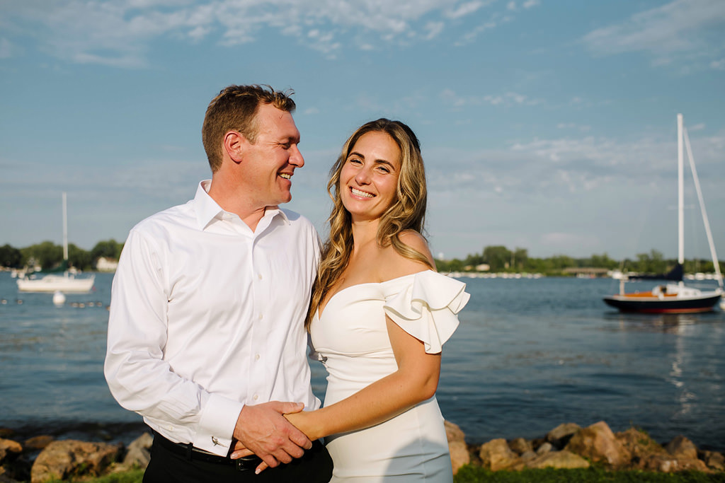 smiling newlyweds beside lake minnetonka in minnesota