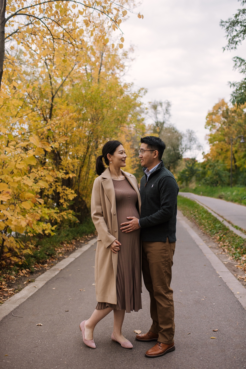 fall colors behind pregnant couple during maternity session