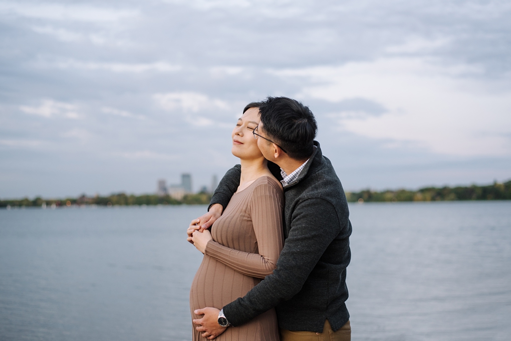 husband kisses pregnant wife during fall maternity session
