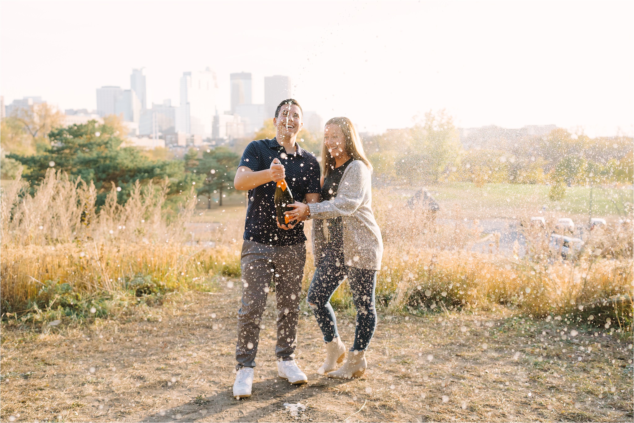 Couple Celebrating Champagne during their Park engagement