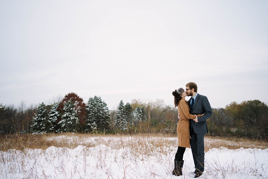 couple kissing in snowy st paul nature preserve