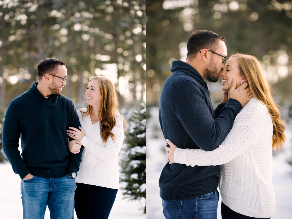 engaged couple walking through snow, man kissing woman's nose in snow