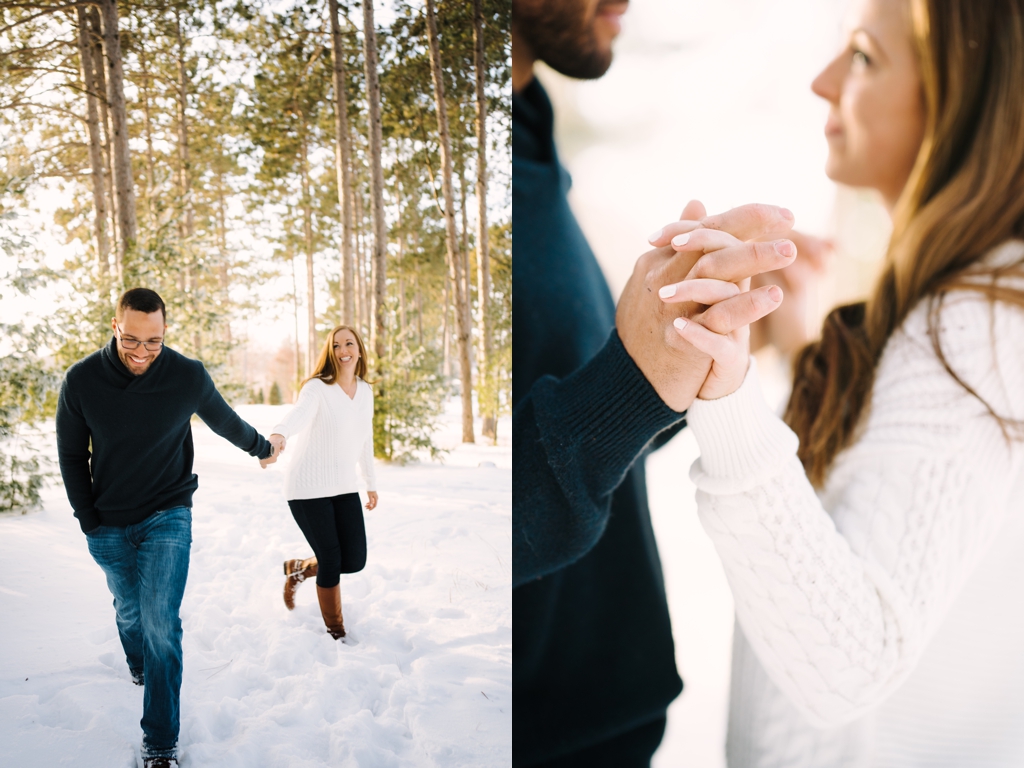 engaged couple holding hands and walking through snow