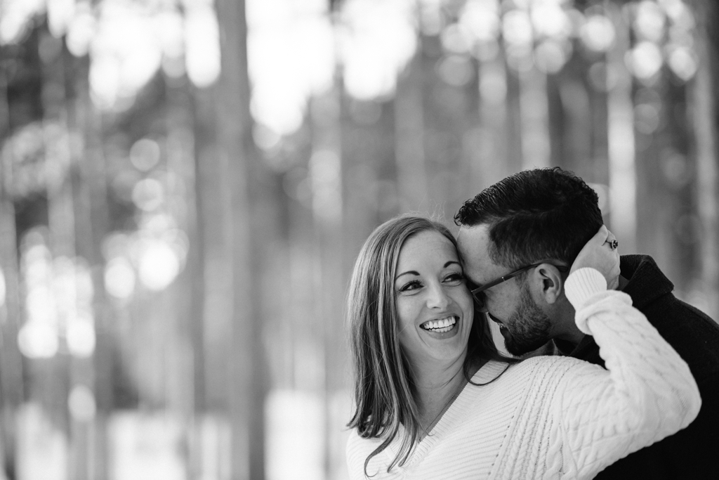 couple embracing during tree farm engagement session