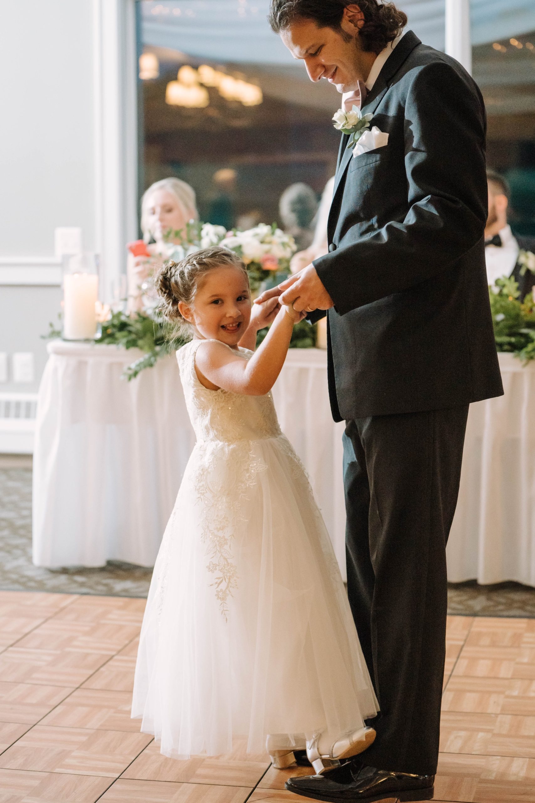 flower girl dancing with dad at wedding reception