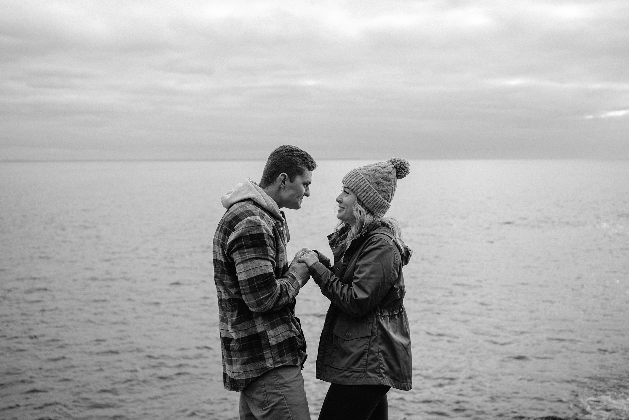 couple holding hands beside lake superior north shore minnesota
