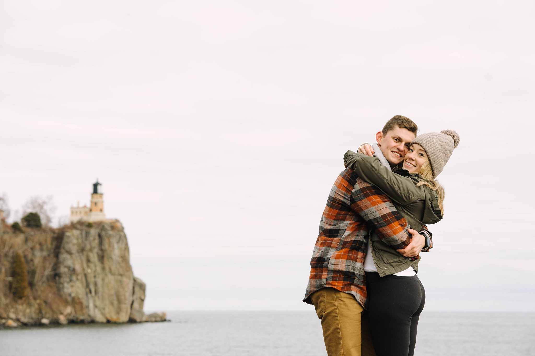 newly engaged couple beside lake superior by split rock lighthouse