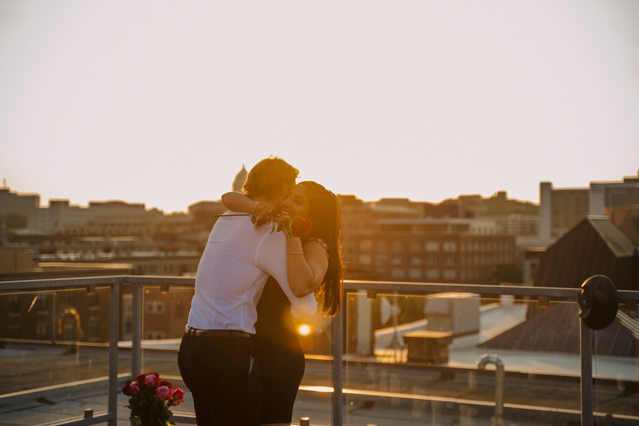 newly engaged couple hugging at sunset