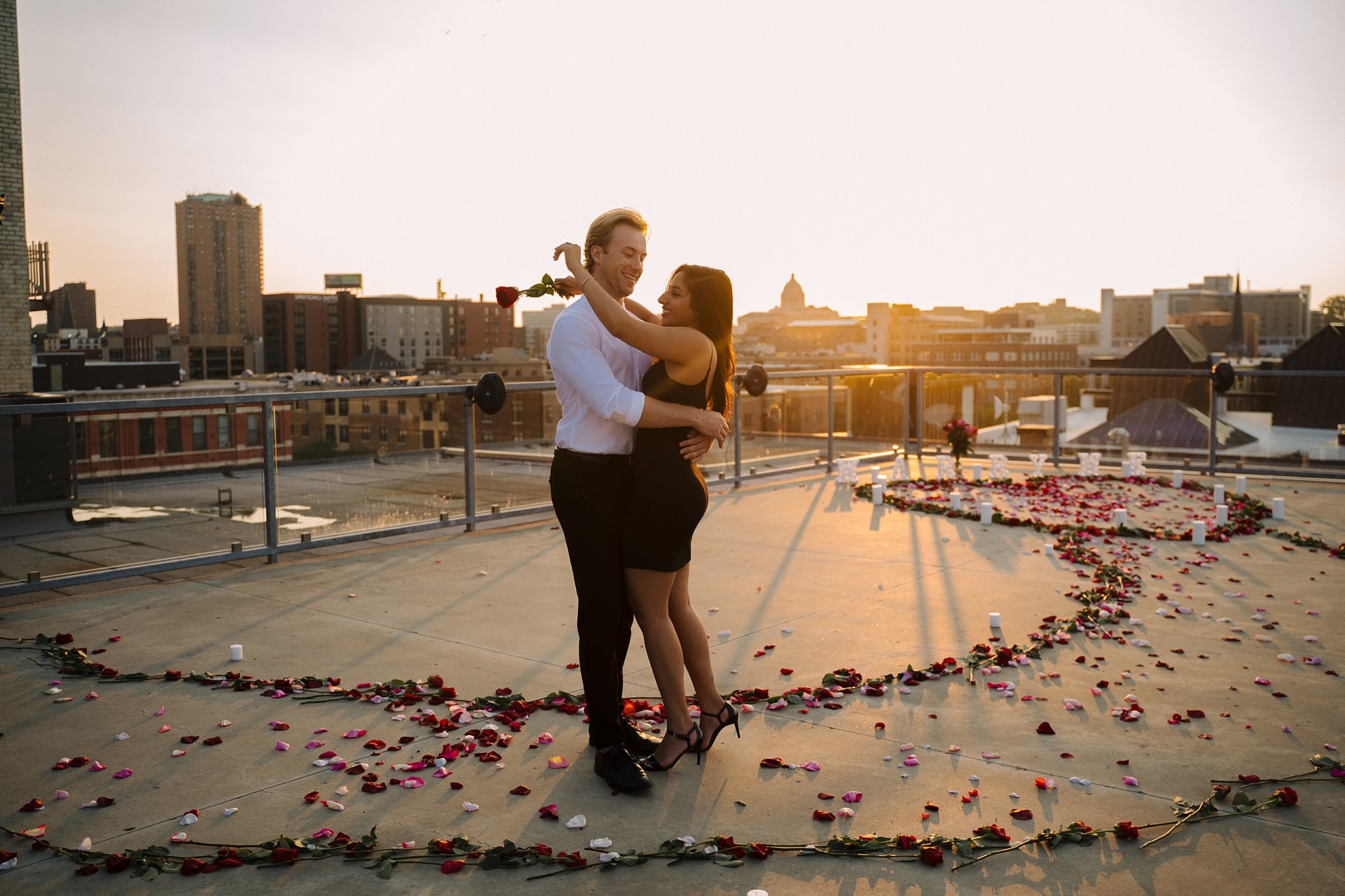 engaged couple embracing with rose petals