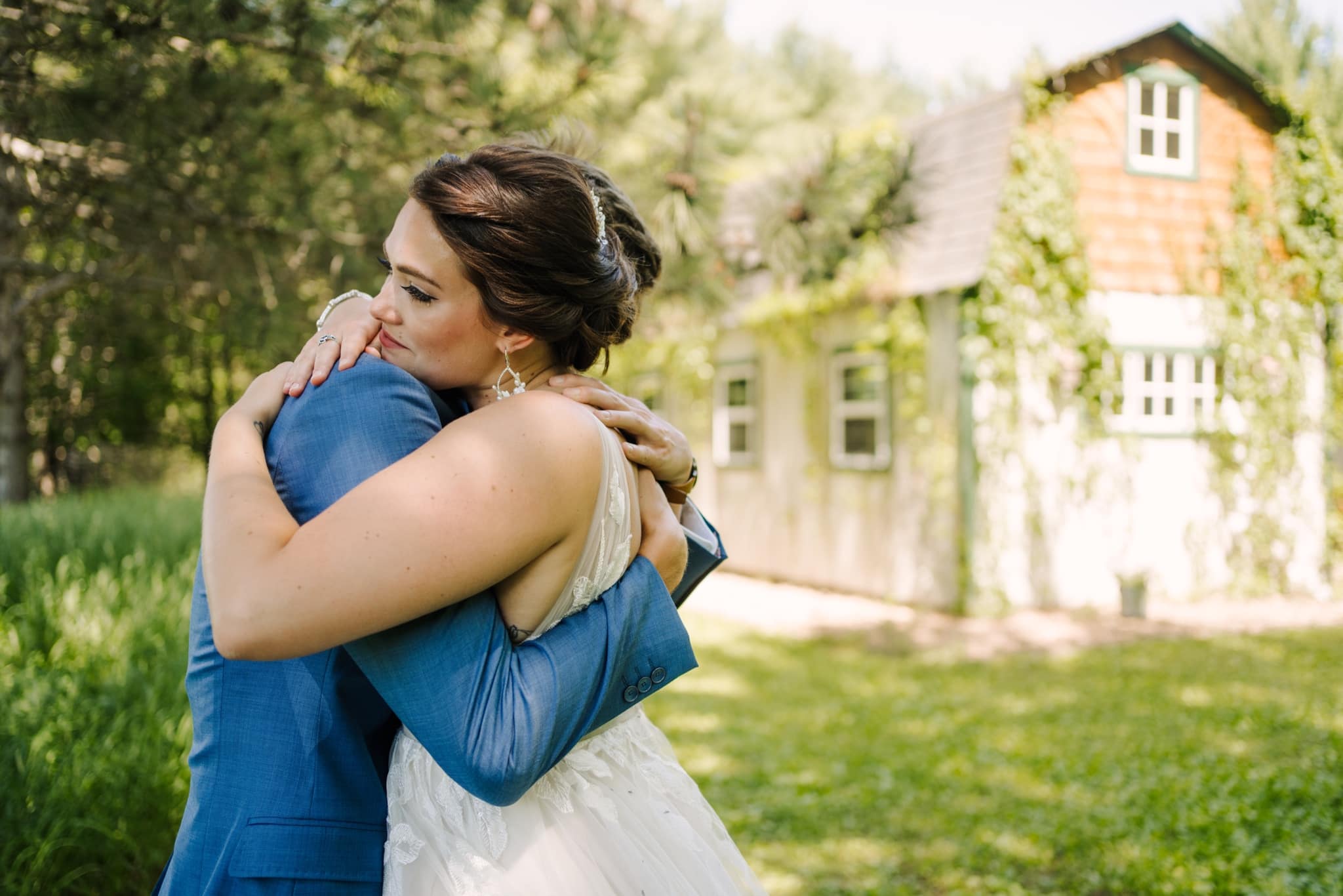 bride and groom hugging outside barn