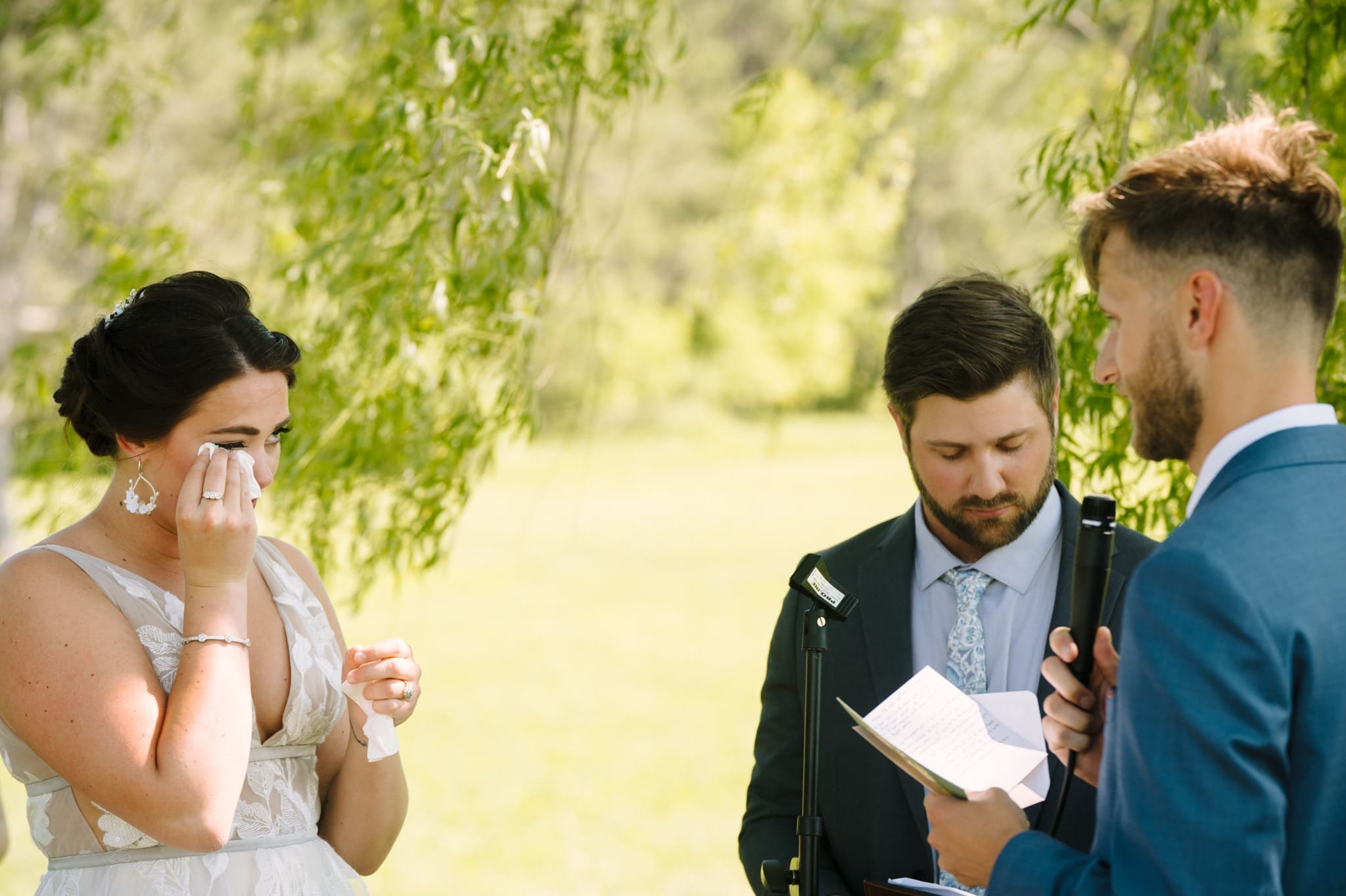 bride and groom exchange vows beneath willow