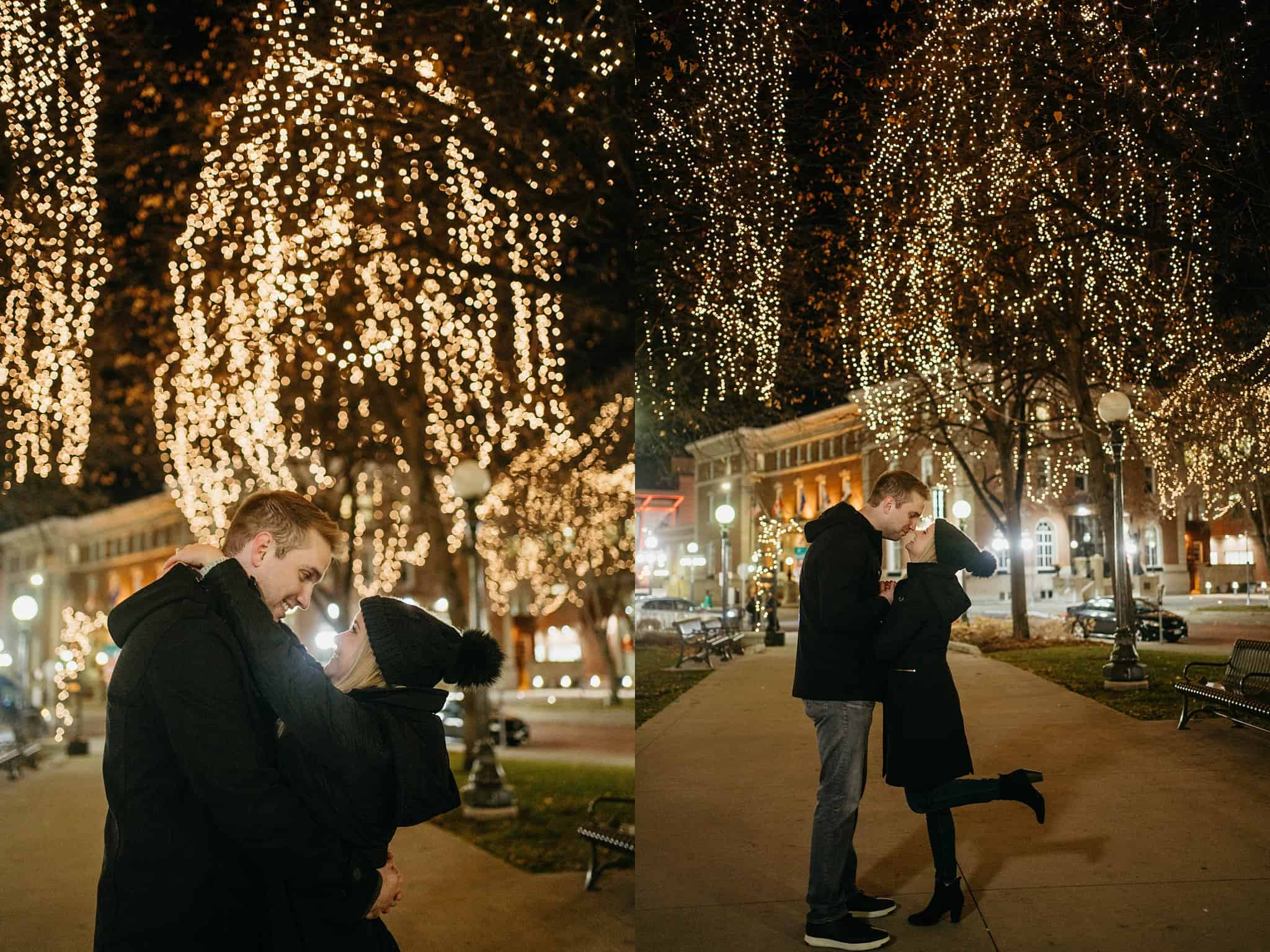 engaged couple kiss under winter lights