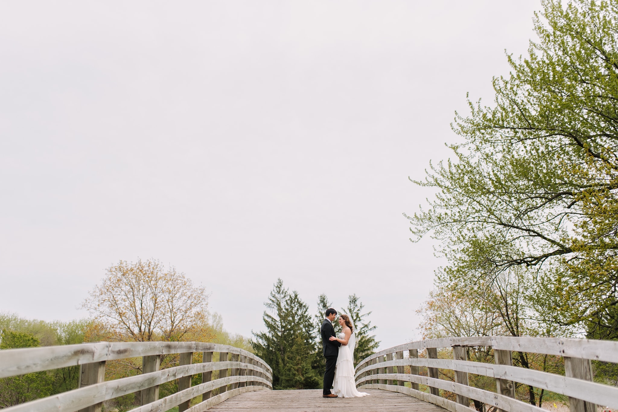 Bride and groom posing on bridge for their Minneapolis wedding photos